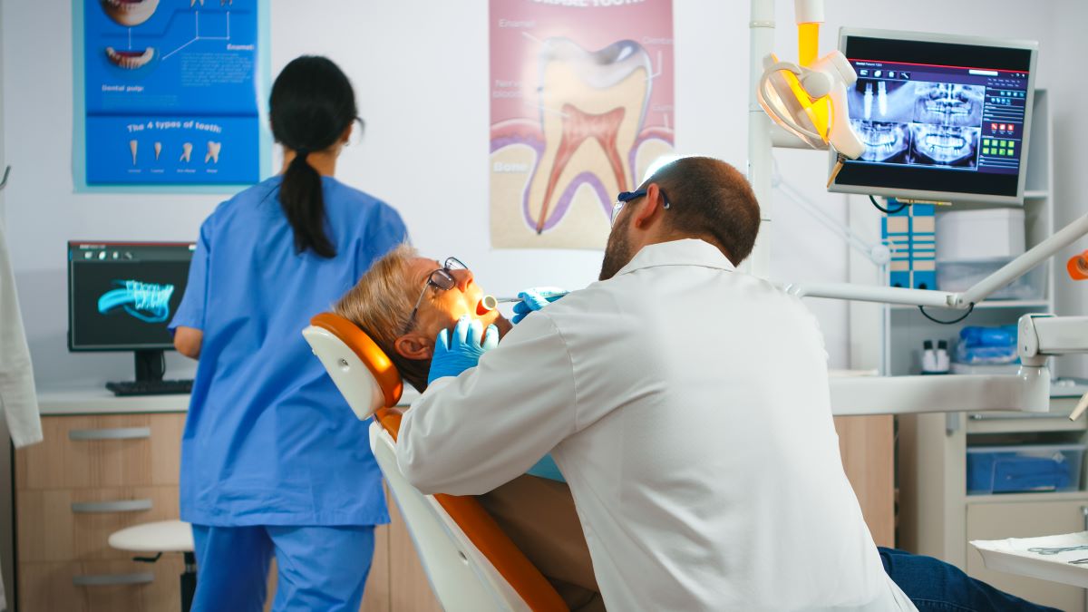 Dentist performing an oral cancer screening on a patient in Hamilton, ON at Charlton Dentistry